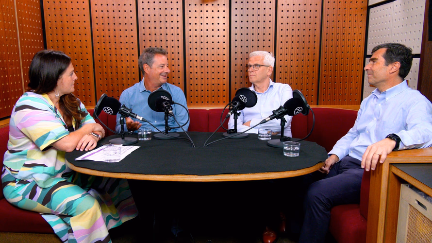 Four people gathered around taking on a podcast